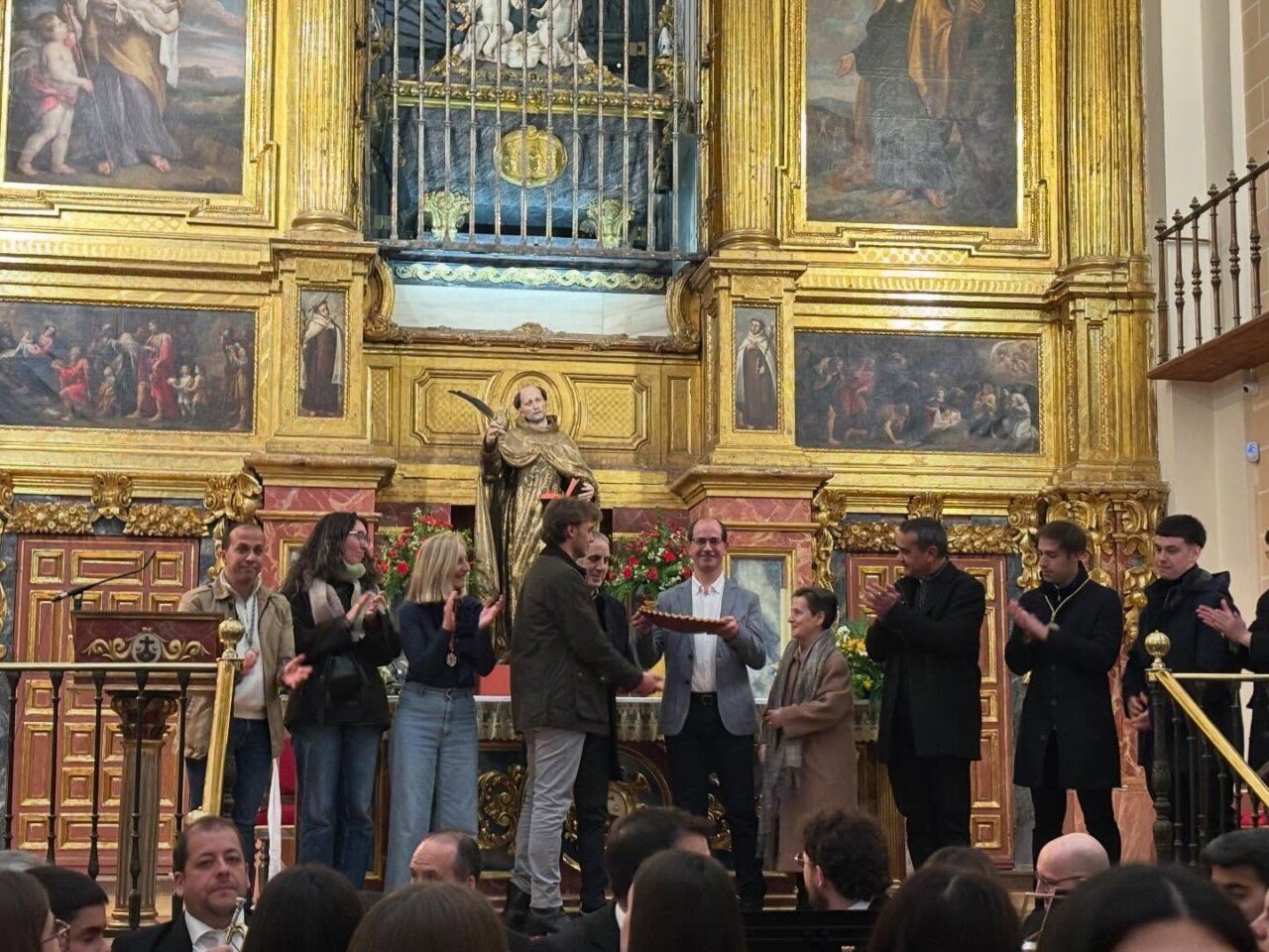 Momento del pregón de Semana Santa en Alba de Tormes con asistentes aplaudiendo.