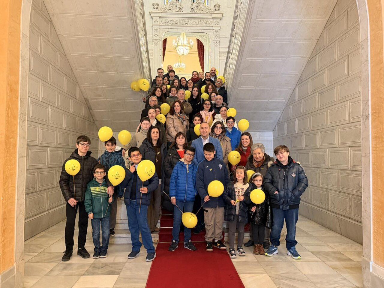Grupo de personas en el Ayuntamiento de Salamanca con globos amarillos
