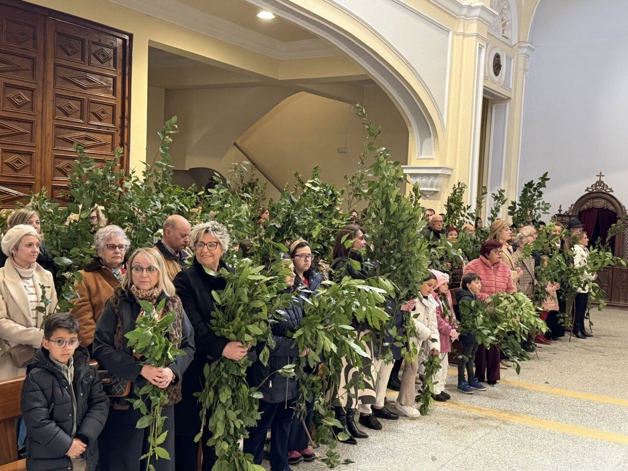 Multitud de personas con ramas en la Iglesia de la Asunción en Guijuelo