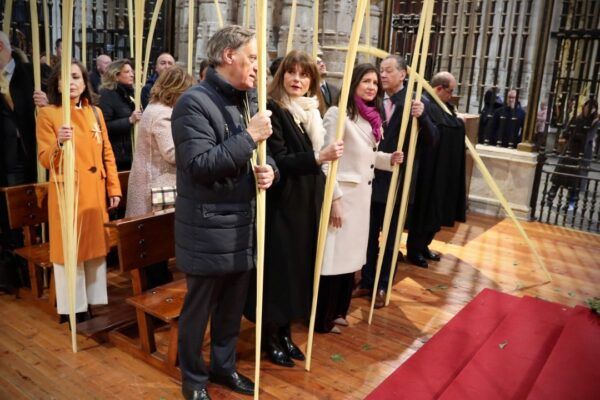 Miembros del Ayuntamiento de Salamanca sosteniendo palmas en la Catedral.