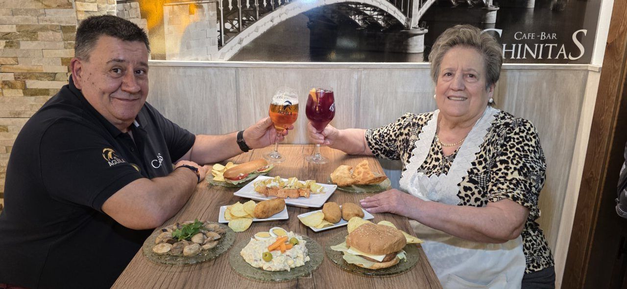Javier y una mujer brindando con bebidas en Café Bar Chinitas