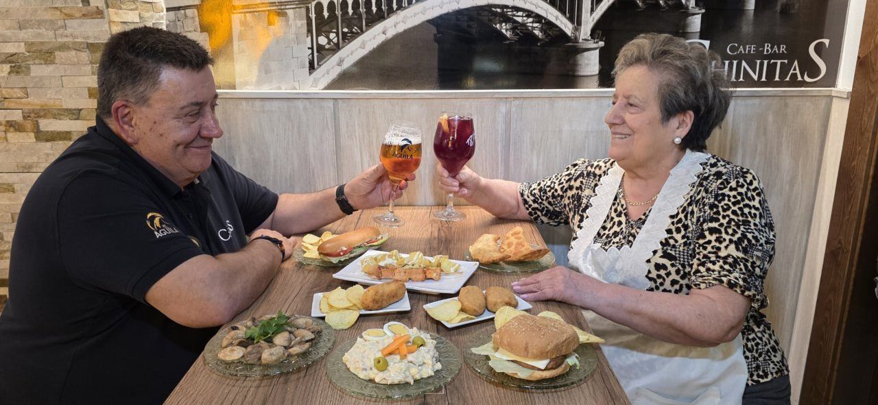 Javier y una mujer brindando con bebidas en Café Bar Chinitas