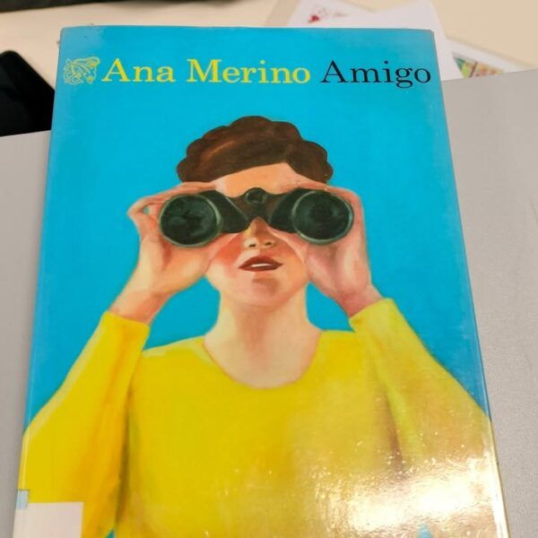 Portada del libro 'Amigo' de Ana Merino con una persona usando binoculares.