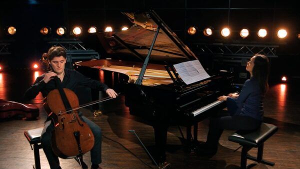 Músicos tocando piano y violonchelo en un concierto