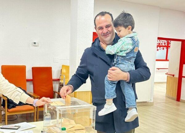 David Mingo Pérez votando con un niño en brazos