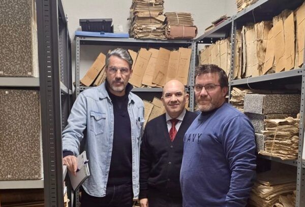 Tres personas en un archivo de documentos antiguos en Salamanca