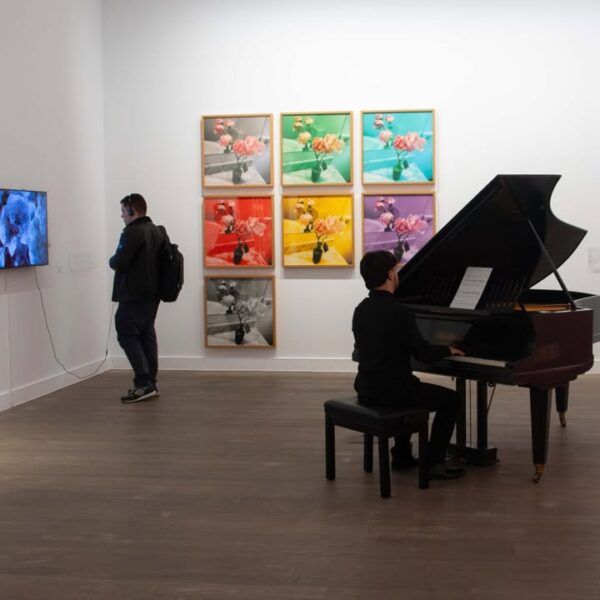 Persona tocando el piano en una exposición de arte contemporáneo