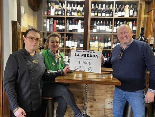 Tres personas sosteniendo un cartel de recaudación en un bar