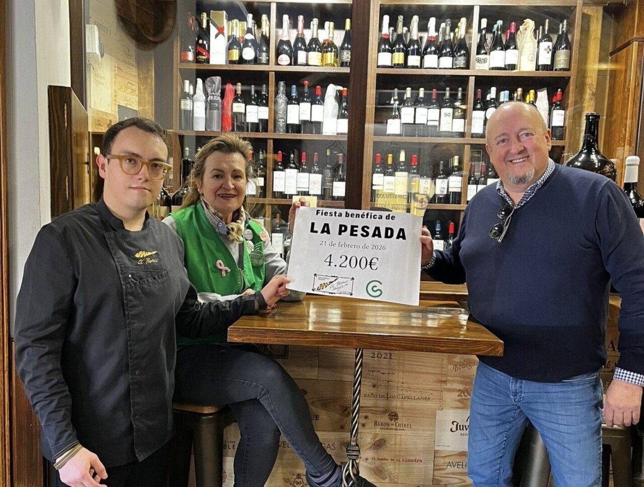 Tres personas sosteniendo un cartel de recaudación en un bar