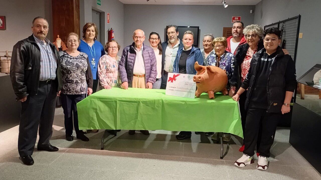 Grupo de personas junto a una hucha solidaria en Guijuelo