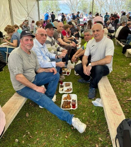 Grupo de personas disfrutando de una comida tras una marcha senderista en Mieza