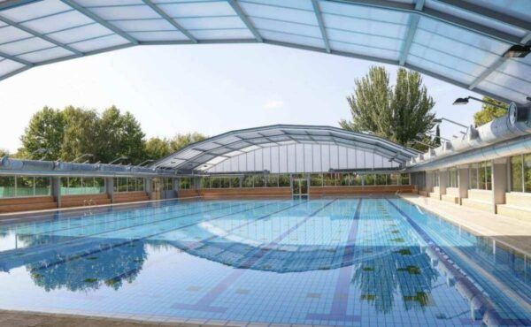Vista de la piscina municipal de Salamanca con techo cubierto y agua clara
