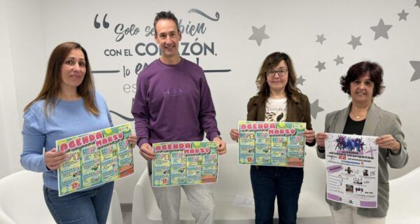 Cuatro personas sosteniendo carteles de la agenda joven de marzo