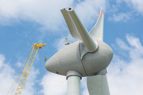 Turbina eólica en construcción con grúa amarilla en el fondo