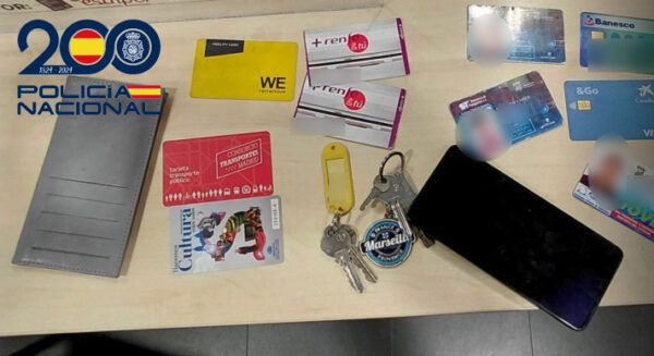 Objetos recuperados tras un robo en un restaurante, incluyendo un teléfono y documentos.