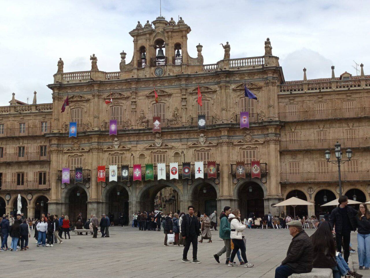 Vista de la Plaza Mayor de Salamanca durante la Semana Santa con gente y banderas.