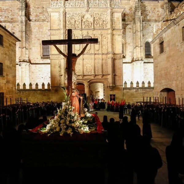 Procesión de Semana Santa en la Universidad de Salamanca con un crucifijo y flores