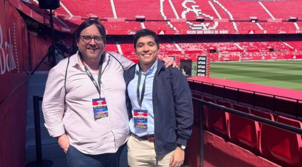 Dos personas sonrientes en un estadio durante un evento deportivo