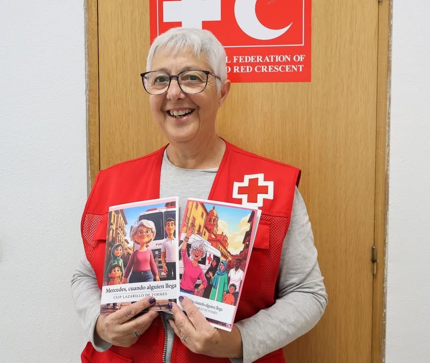 Mercedes, voluntaria de Cruz Roja, sonríe con libros en las manos