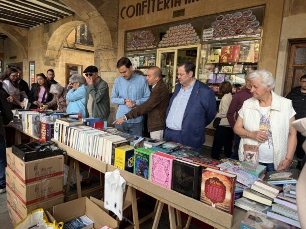 Personas visitando un mercado de libros en Salamanca durante el Día del Libro