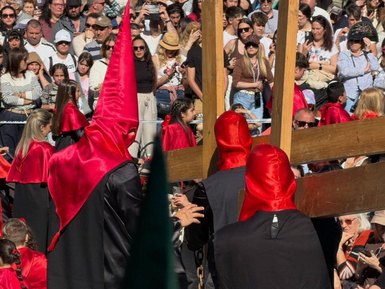Participantes de la Hermandad del Silencio en una procesión con capirotes rojos
