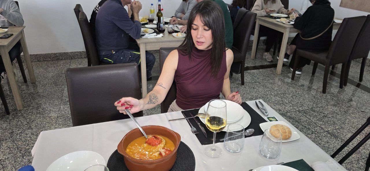 Mujer degustando arroz con bogavante en un restaurante
