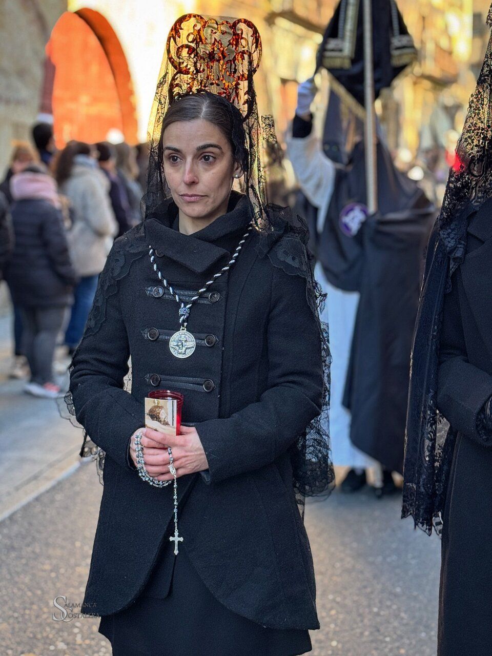 Mujer con velo negro sosteniendo una vela en la Semana Santa