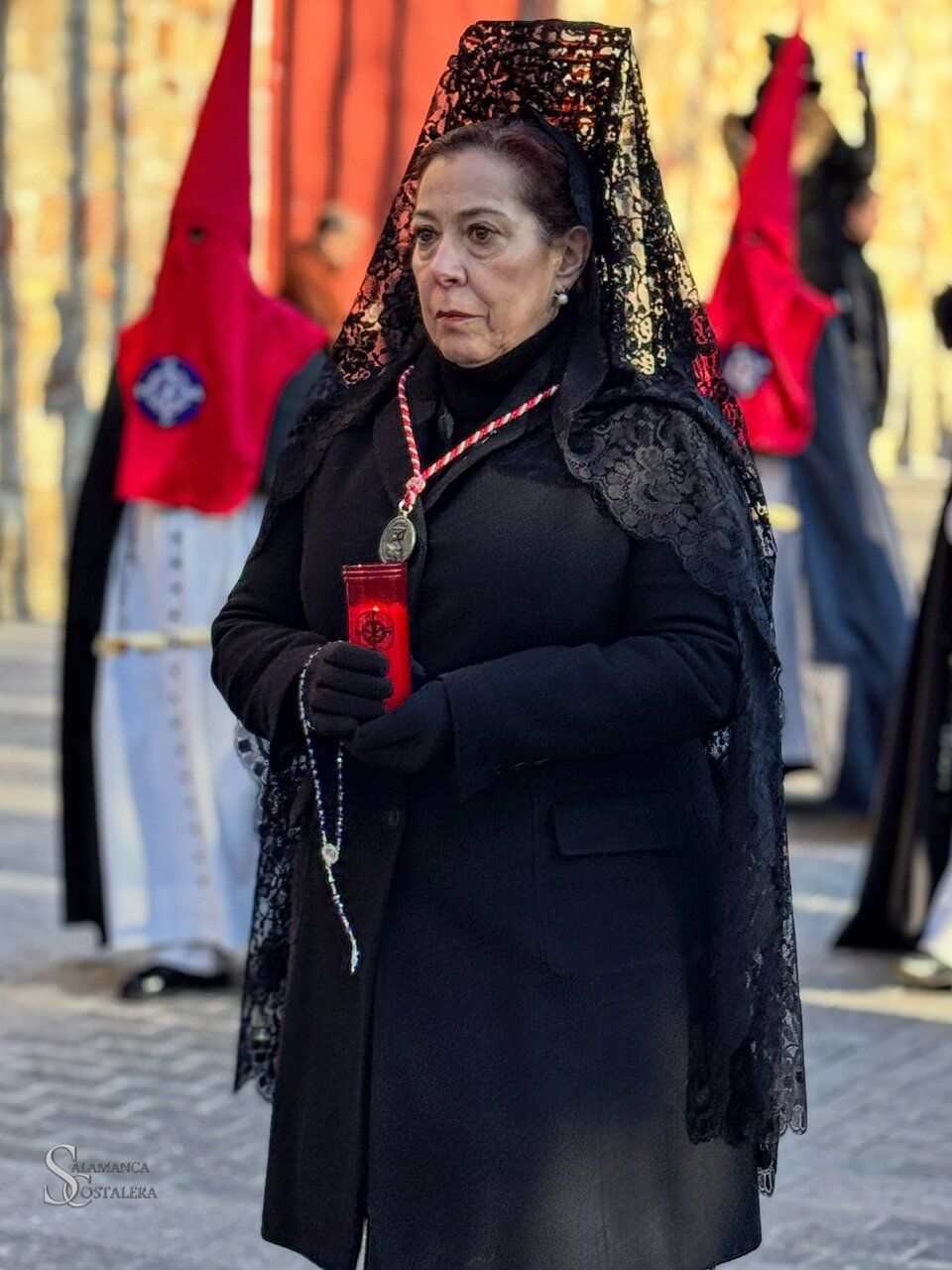 Mujer con velo negro sosteniendo una vela en la Semana Santa