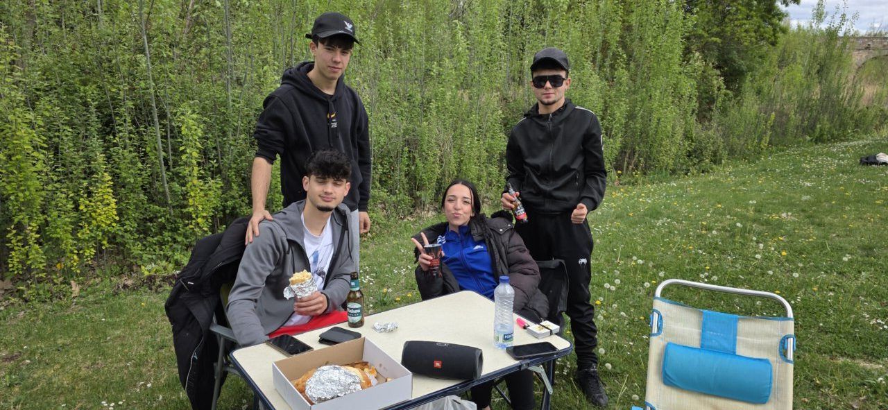 Grupo de jóvenes disfrutando del Lunes de Aguas en Salamanca con comida y bebida.