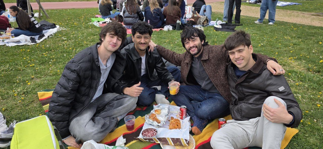 Grupo de amigos disfrutando del Lunes de Aguas en Salamanca con comida y bebida.