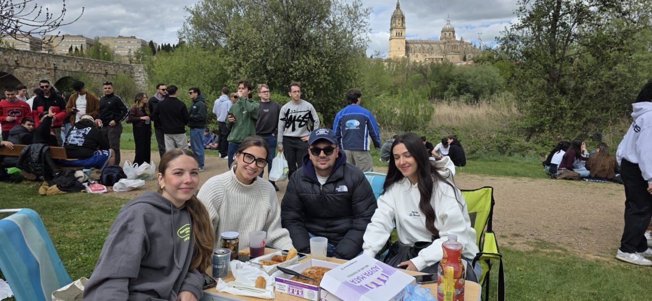 Grupo de amigos disfrutando del Lunes de Aguas en Salamanca con comida y bebida