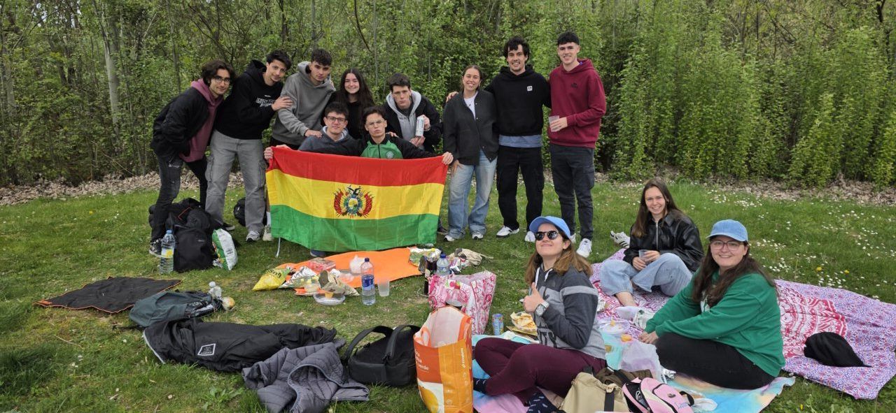 Grupo de jóvenes celebrando Lunes de Aguas con bandera boliviana