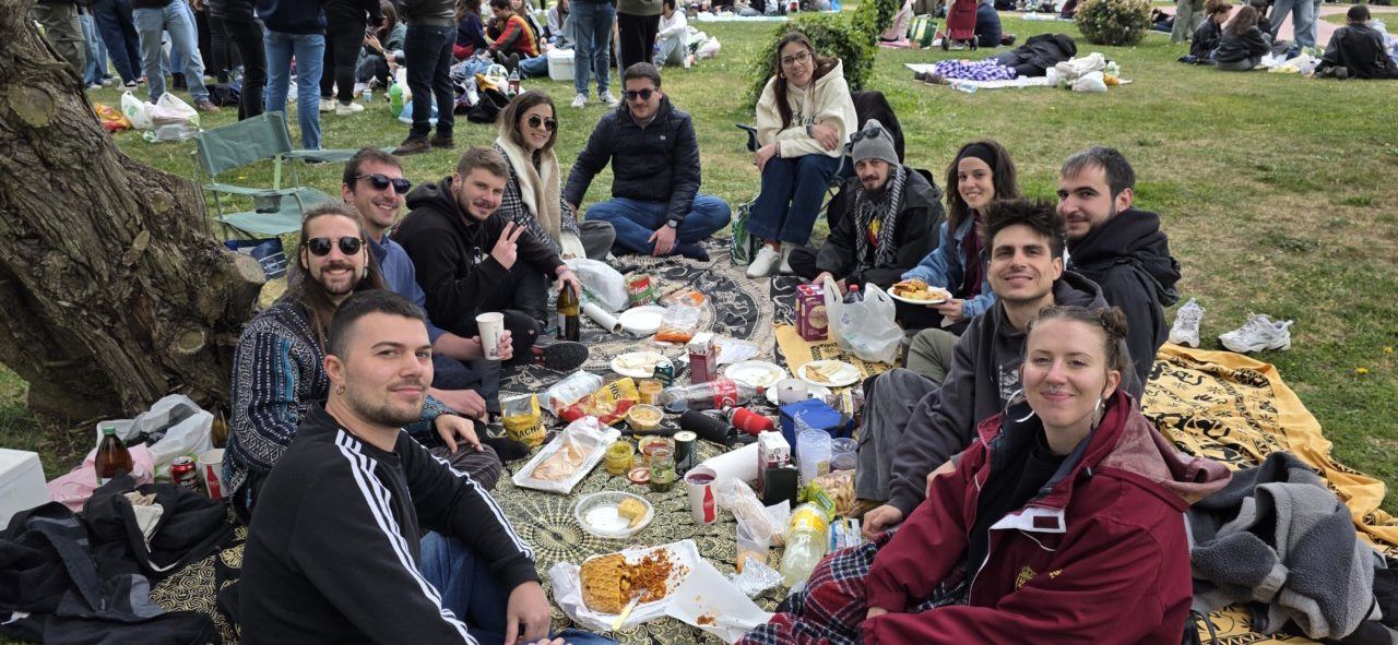Grupo de amigos disfrutando del Lunes de Aguas en Salamanca con comida y bebida.