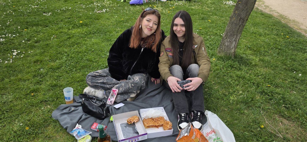 Dos jóvenes disfrutando del Lunes de Aguas en Salamanca con comida típica.