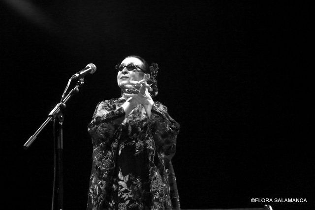 Artista Martirio actuando en un escenario con micrófono