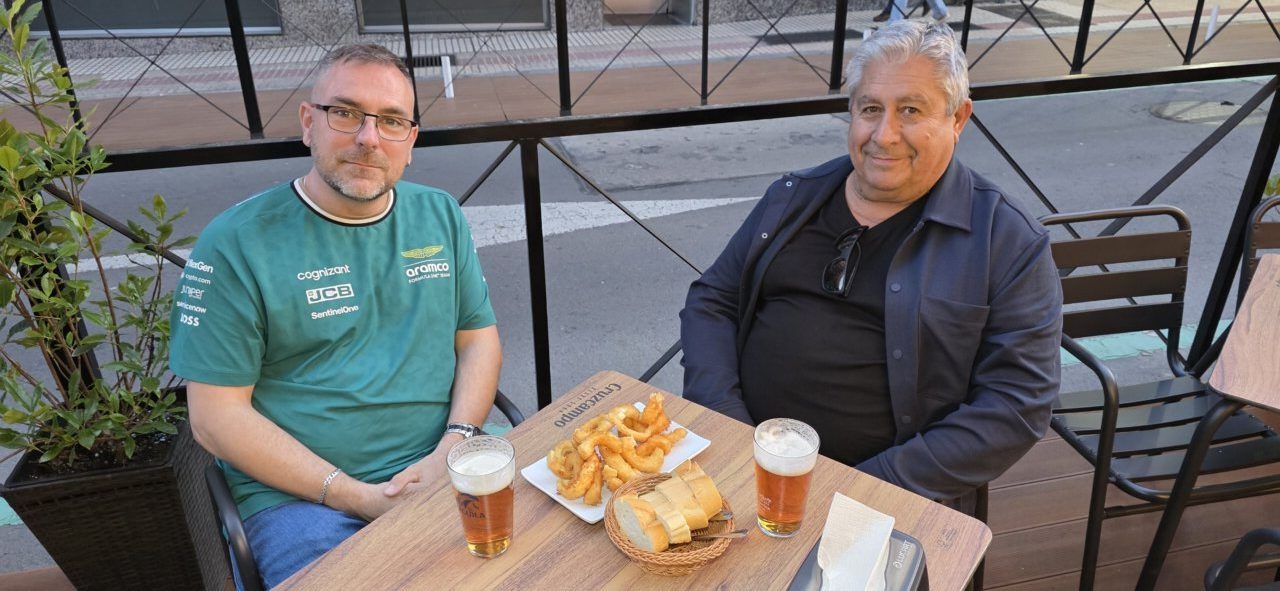 Dos hombres disfrutando de tapas y cervezas en la terraza del Café Bar Chinitas.