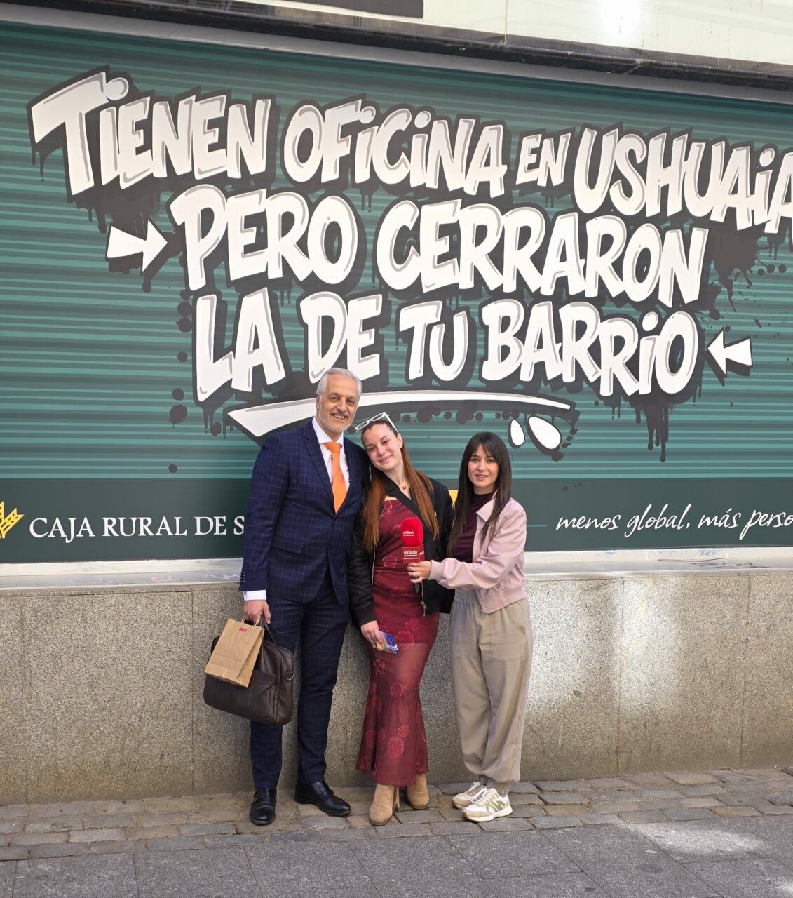 Tres personas posando frente a un mural de Caja Rural de Salamanca