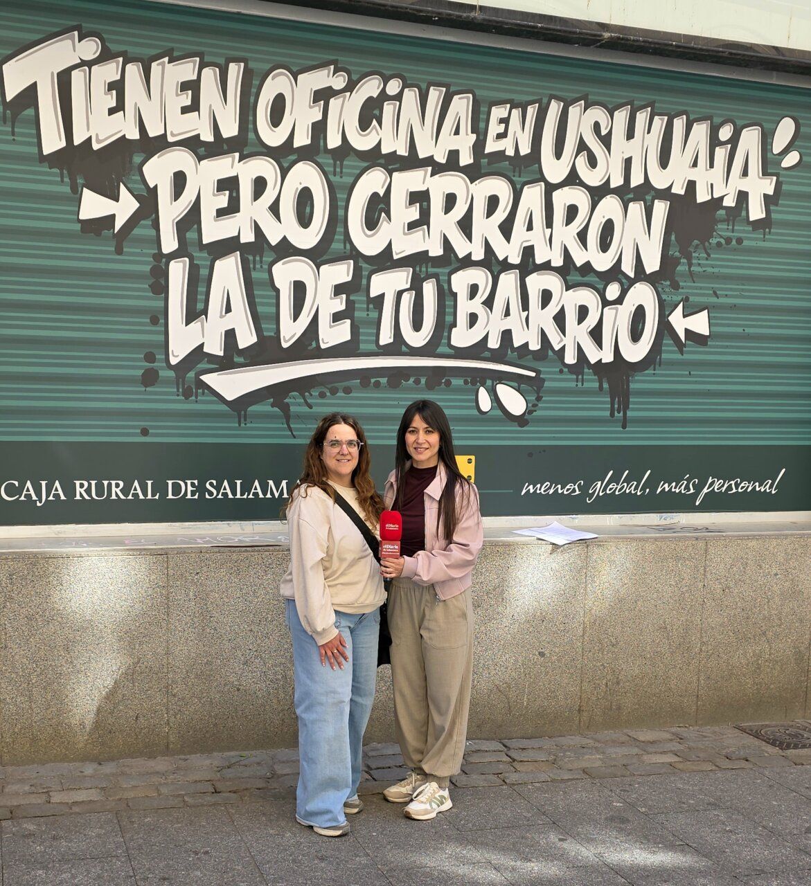 Dos mujeres frente a un mural de Caja Rural de Salamanca
