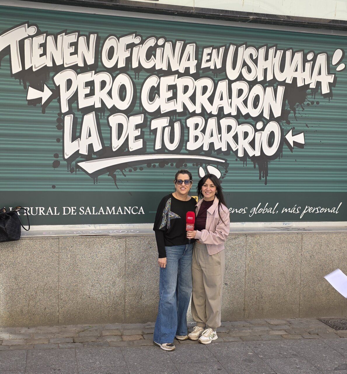 Dos mujeres posando frente a un mural de Caja Rural de Salamanca