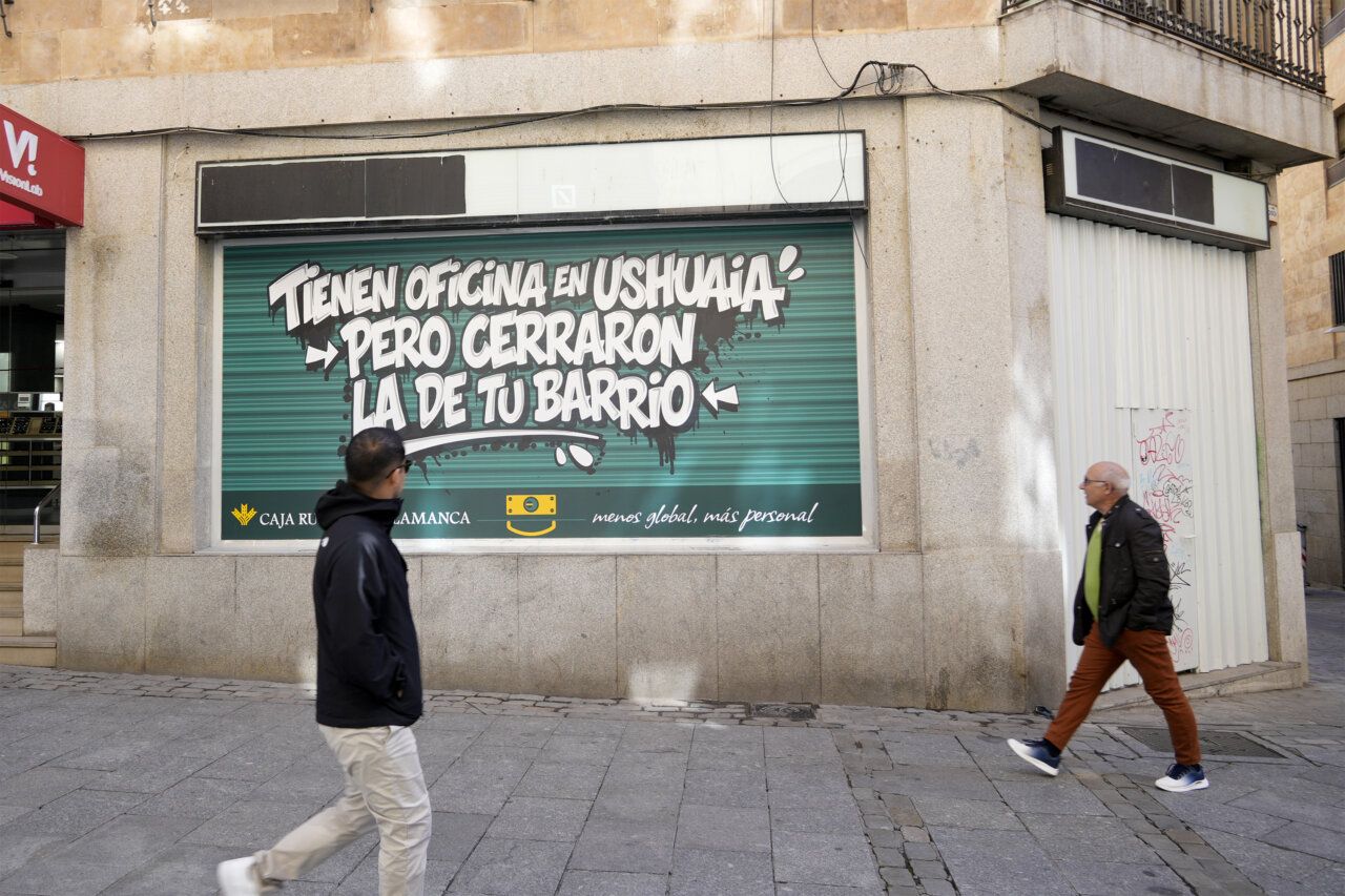 Hombres caminando frente a un mural en Salamanca