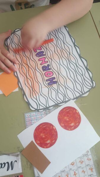 Niño coloreando un dibujo sobre hornazo en una actividad escolar