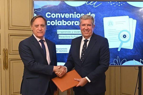 Dos hombres estrechando manos durante la firma de convenios de colaboración