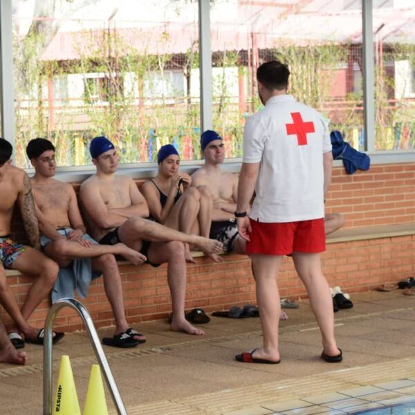 Jóvenes en clase de socorrismo acuático con instructor de Cruz Roja