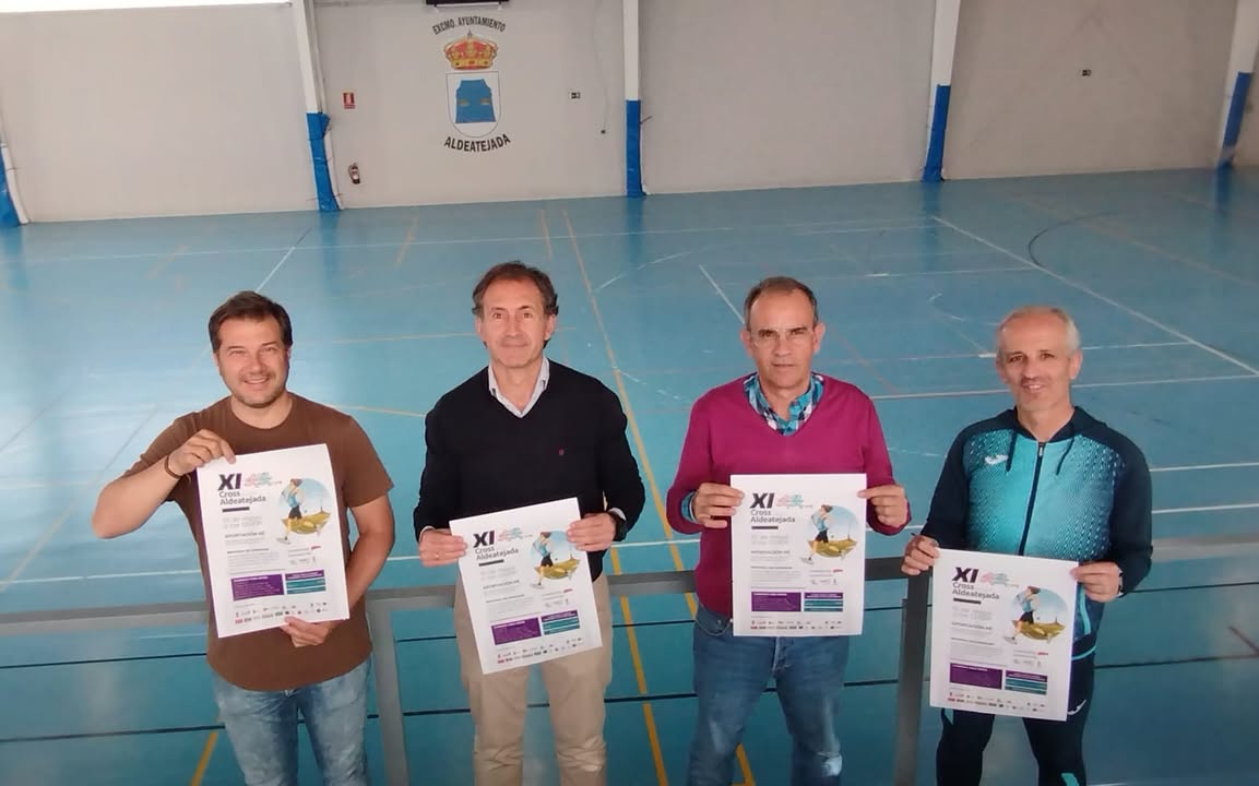 Cuatro personas sosteniendo carteles del XI Cross Popular de Aldeatejada