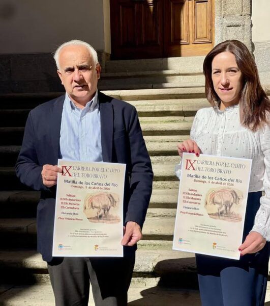 Dos personas sosteniendo carteles de la IX Carrera Campo del Toro Bravo