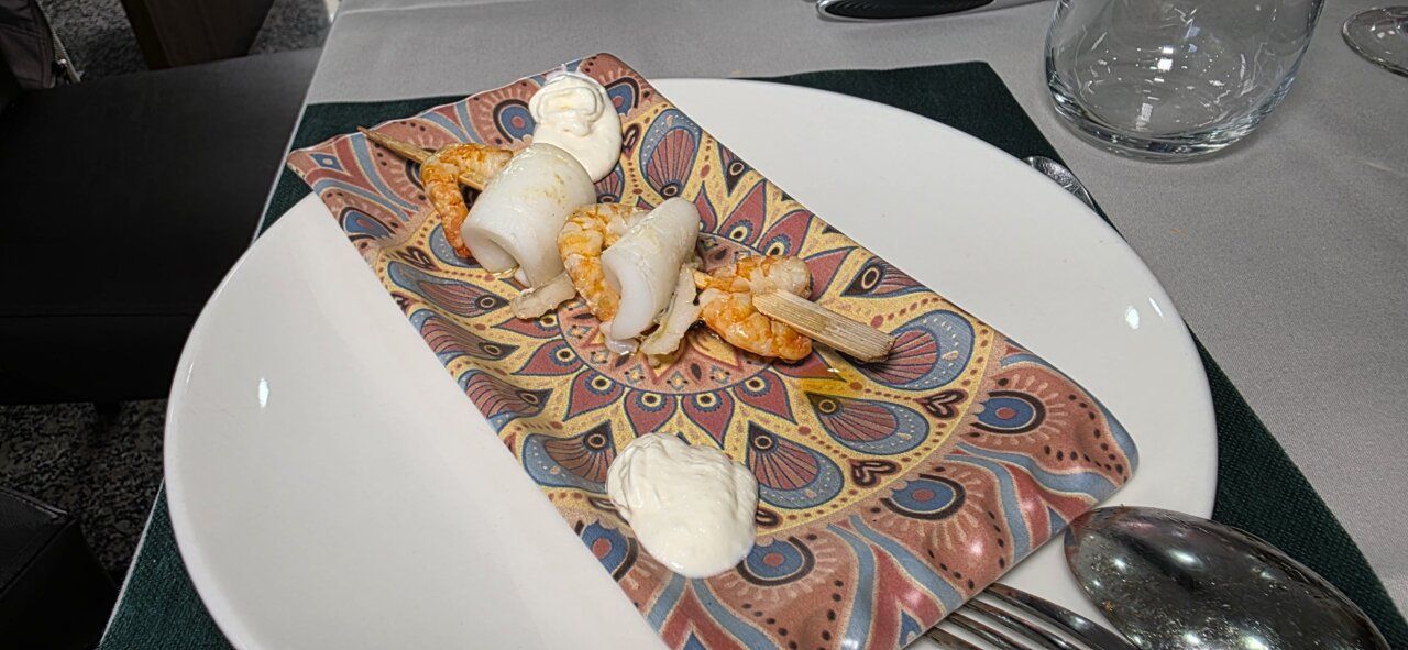 Plato de entrantes con sepia y gambas en restaurante