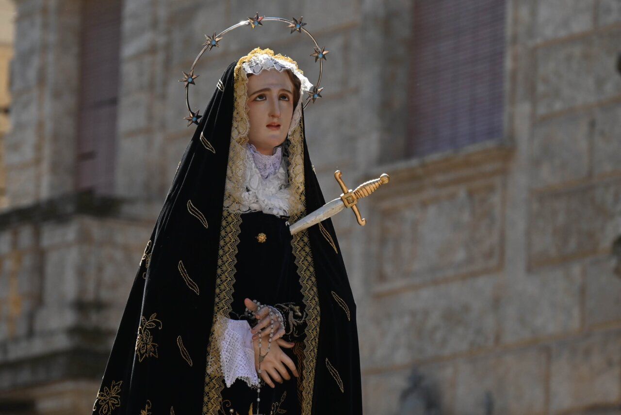 Imagen de una figura religiosa con un vestido negro y una espada.