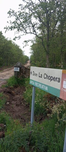 Señal de dirección hacia el área recreativa La Chopera en un camino mejorado
