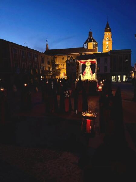 Procesión del Jueves Santo en Peñaranda de Bracamonte con luces y figuras religiosas.