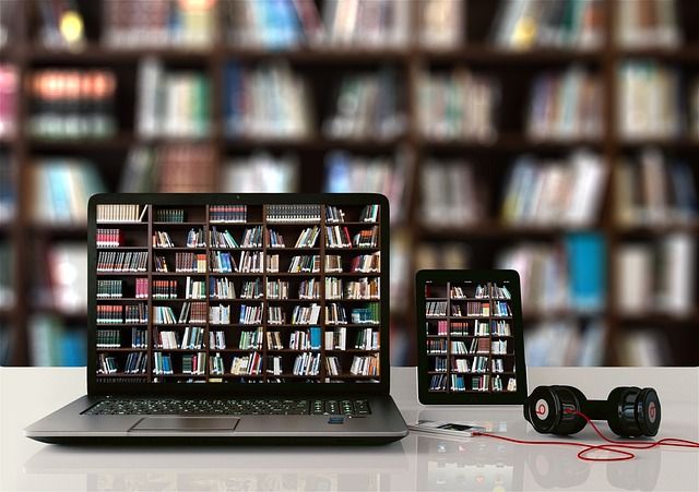 Computadora y tablet mostrando estanterías de libros en un entorno educativo.